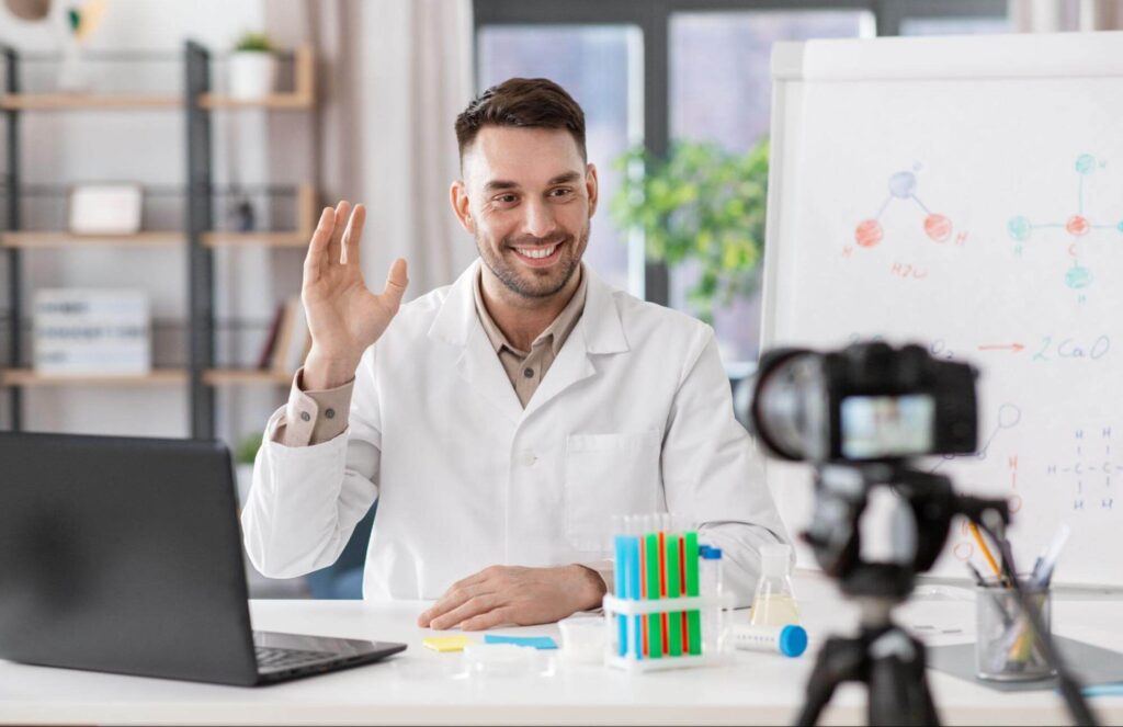 scientist waving at a camera