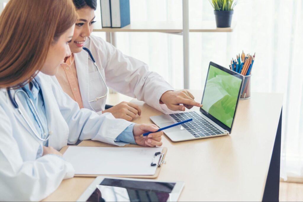 Doctor pointing at laptop screen.