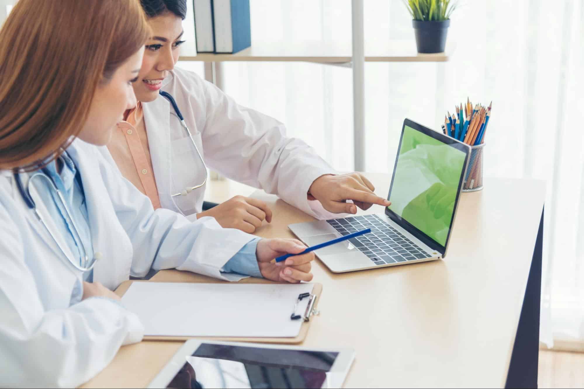 Doctor pointing at laptop screen.